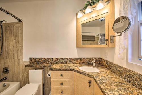 a bathroom with a sink and a toilet and a mirror at Private Pool and Dock Coconut Creek Home! in Coconut Creek