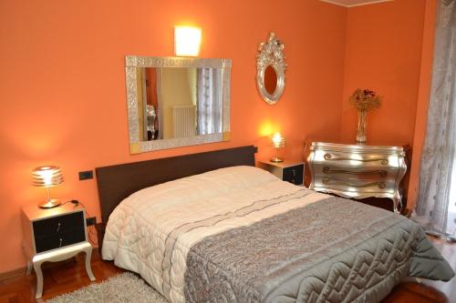 a bedroom with orange walls and a bed and a mirror at B&B Ai Prati in Bergamo