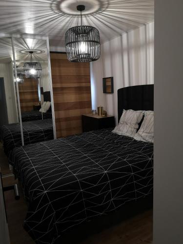 une chambre avec un grand lit et un lustre dans l'établissement L'albatros - Vue mer, à Saint-Hilaire-de-Riez