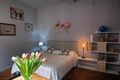 a bedroom with a bed and a table with flowers at Studio Neve in Bologna