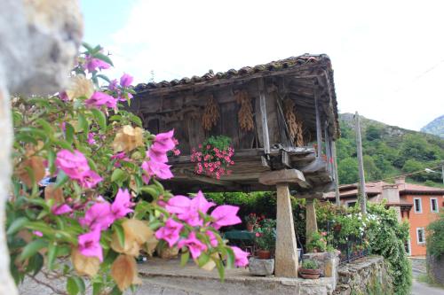 een klein huis met bloemen ervoor bij El Colladín in Llerices