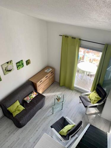 un salon avec un canapé, des chaises et une fenêtre dans l'établissement Coup de cœur à Sanary sur Mer, à Sanary-sur-Mer