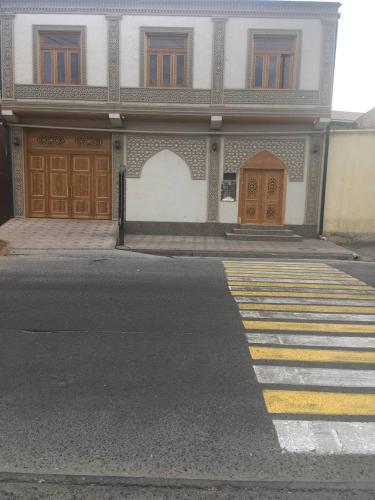 an empty street with a building with wooden doors at Uzbek House in Samarkand