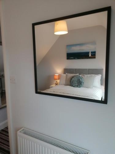 a mirror on the wall of a bedroom with a bed at Atlantic way Apartment 1 in Breaghwy