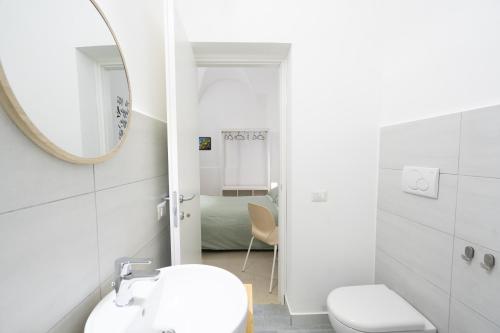 a white bathroom with a sink and a mirror at Be happy Rooms in Catania