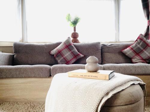 a living room with a couch and a book on a table at Sea Breeze in Scarborough