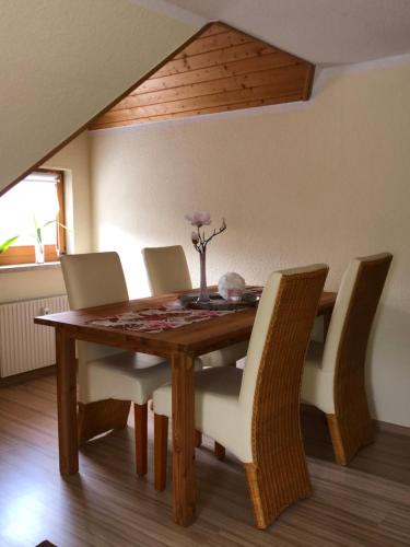 stół jadalny z krzesłami i drewniany stół w obiekcie Ferienwohnung Hänel w mieście Antonshöhe