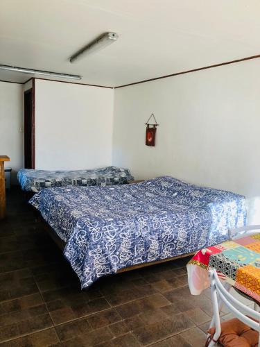 a bedroom with two beds and a table at Departamento Eusebio Lillo in Coihaique