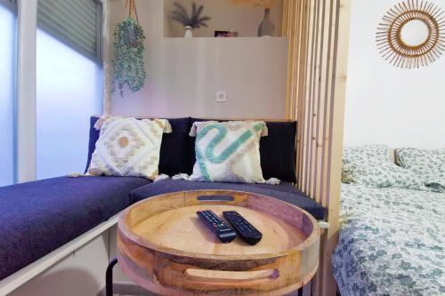 Pokój z łóżkiem i dwoma pilotami na stole w obiekcie Studio design tout équipé avec netflix & terrasse w mieście Bourg-en-Bresse