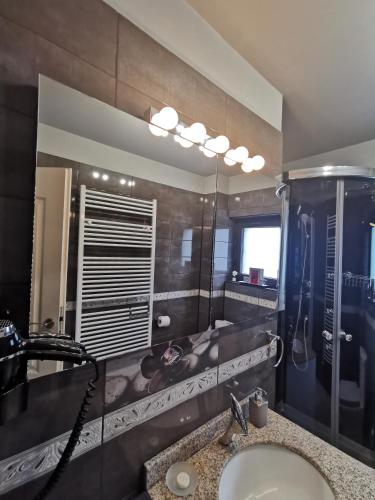a bathroom with a sink and a shower and a mirror at Apartament Kalinderu K2 Busteni in Buşteni