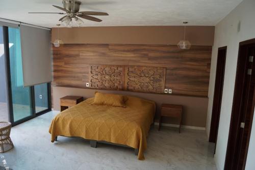 een slaapkamer met een bed met een houten muur bij Residencia y piscina climatizada in La Venta del Astillero