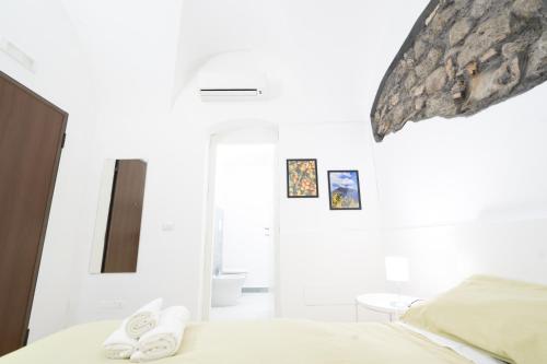 a bedroom with white walls and a bed with slippers at Be happy Rooms in Catania