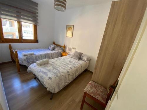 特倫普的住宿－Sant Jordi 2，一间卧室设有两张床,其中设有窗户。