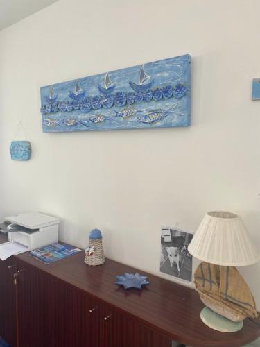 a desk with a lamp and a picture on the wall at Residenza Le Spiagge in Sperlonga