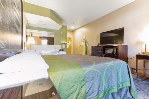 a hotel room with a bed and a flat screen tv at Super 8 by Wyndham Uniontown PA in Uniontown