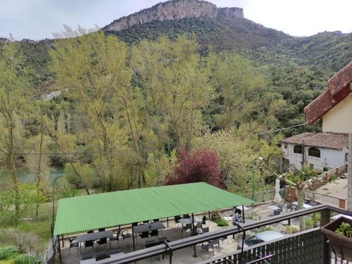 a green covering on a patio with a mountain at Hotel Durtzi in Sobrón