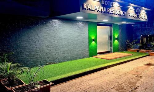 a house with a green lawn in front of a wall at KALPANA RESIDENCY - Near US Embassy in Mumbai