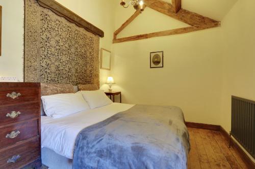 a bedroom with a bed and a dresser in a room at Derbyshire Chapel for 6 at Harthill Hall private hot tub 8am - 10pm plus private daily use of indoor pool and sauna 1 hour in Stanton in Peak