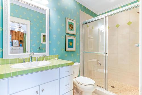 a bathroom with a shower and a toilet and a sink at Tenth Street Retreat in Tybee Island