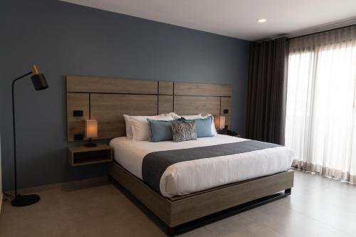 a bedroom with a large bed with a wooden headboard at TH HOTEL & VIVIENDA in Tepatitlán de Morelos