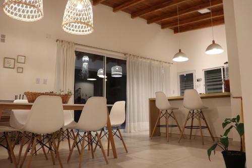 a kitchen with white chairs and a kitchen island at Quinta El Hornero in Esperanza