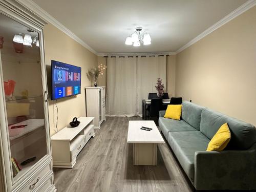 sala de estar con sofá y mesa en Moderns, gaišs, plašs! A++ 3 istabu dzīvoklis, en Riga