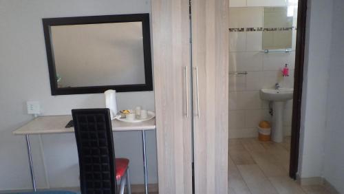 a bathroom with a sink and a mirror at Kadichueni Guest House in Zeerust