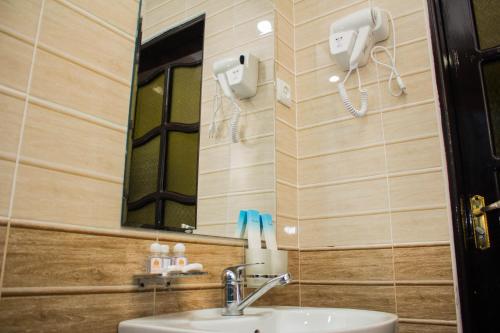 La salle de bains est pourvue d'un lavabo et d'un miroir. dans l'établissement Jahangir Boutique Bukhara, à Boukhara