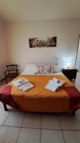 1 dormitorio con 1 cama con toallas en La Casetta di Zia Palmina, en Recanati