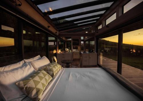 a bed sitting inside of a house with windows at Kokomea PurePod in Te Horo