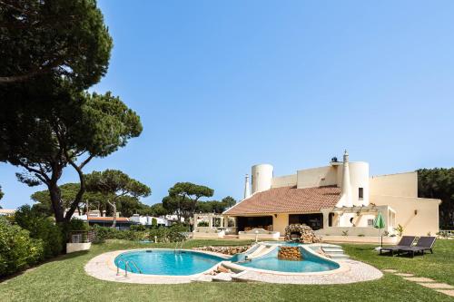 a pool in the yard of a house at Home Out Vila do Lince - 8 Ensuite, Heated Pool & Gym - Marina Vilamoura in Vilamoura