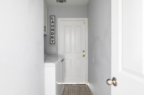 cocina blanca con puerta blanca y suelo de madera en Modern 6 Bedrooms Hollywood Urban Home, en Los Ángeles