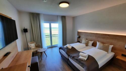 a hotel room with a bed and a television at Hotel Gasthof Sonnenhang in Denkendorf