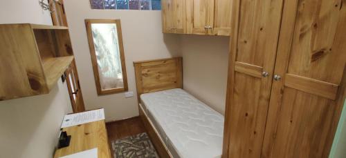 um pequeno quarto com um beliche e armários de madeira em Nocturne Family House em Paola
