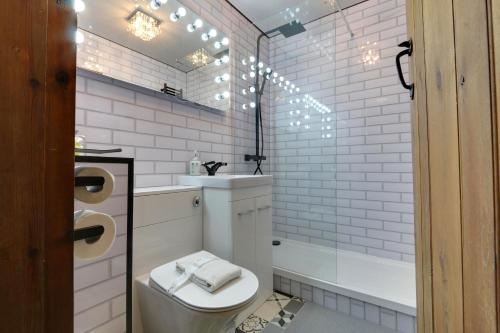 a white bathroom with a toilet and a sink at Priesthill HotTub Pool Dog Friendly PeakDistrict in Stanton in Peak