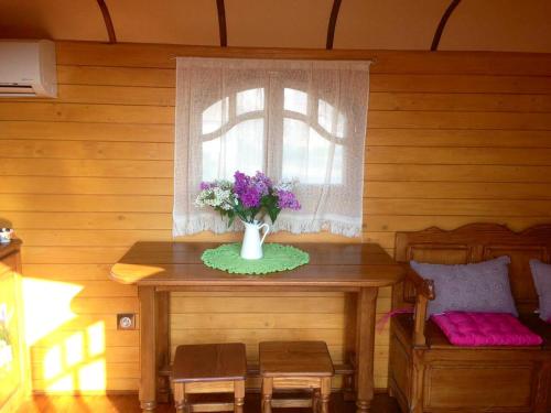 a room with a table with a vase of flowers on it at Bungalow confortable à Saintes-Maries-de-la-Mer avec piscine in Saintes-Maries-de-la-Mer