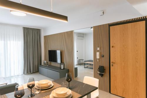 a living room with a dining table and a television at Valentinos Apartments in Kallithea Halkidikis
