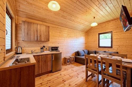 a kitchen and living room in a log cabin at DOMKI JANTAR PREMIUM in Bobolin