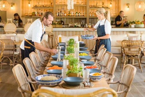 a man and woman preparing a long table with food at Wyndham Palmas Beach and Golf Boutique Resort in Humacao