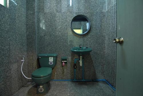 a bathroom with a green toilet and a sink at GO INN The Grand Palace - Mrt Samyot Station in Bangkok