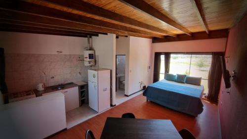 Cet appartement comprend une chambre avec un lit et une table ainsi qu'une cuisine. dans l'établissement Galeano Aparts, à Santa Rosa