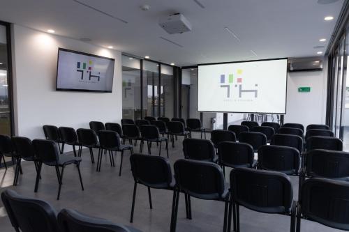 a conference room with chairs and a projection screen at TH HOTEL & VIVIENDA in Tepatitlán de Morelos