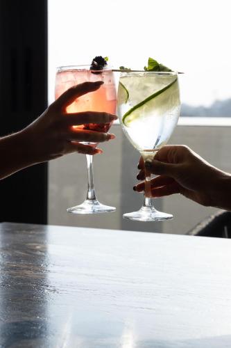 two hands holding cocktails on a table at TH HOTEL & VIVIENDA in Tepatitlán de Morelos