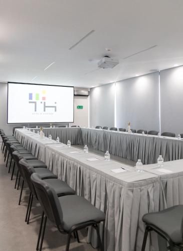 a row of tables and chairs in a room with a screen at TH HOTEL & VIVIENDA in Tepatitlán de Morelos
