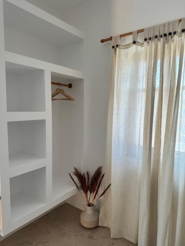 a white curtain in a room with a window at Peristerionas Estate in Karistos