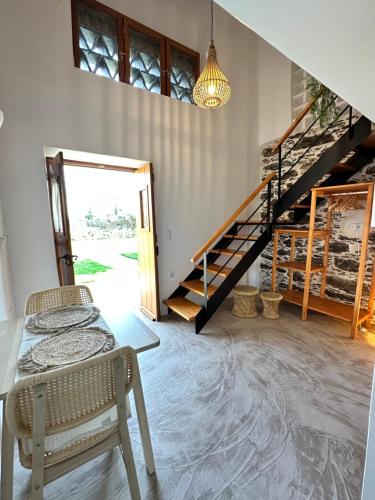 a room with a staircase and a table and chairs at Peristerionas Estate in Karistos