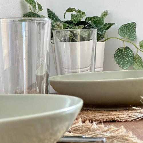 a table with plates and glasses and potted plants at Peristerionas Estate in Karistos