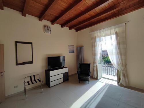 a living room with a television and a chair at IN CENTRO Rooms and Apartments in Isola del Liri