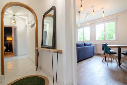 - un salon avec un miroir et un canapé bleu dans l'établissement Saint Germain 2 chambres Parking, à Annecy