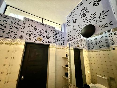 a bathroom with a black door and white tiles at Boutique hotel and gallery in San Angel Inn in Mexico City